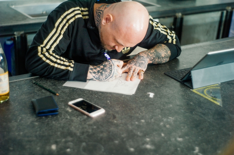 An image of a tattoo artist on IYNK